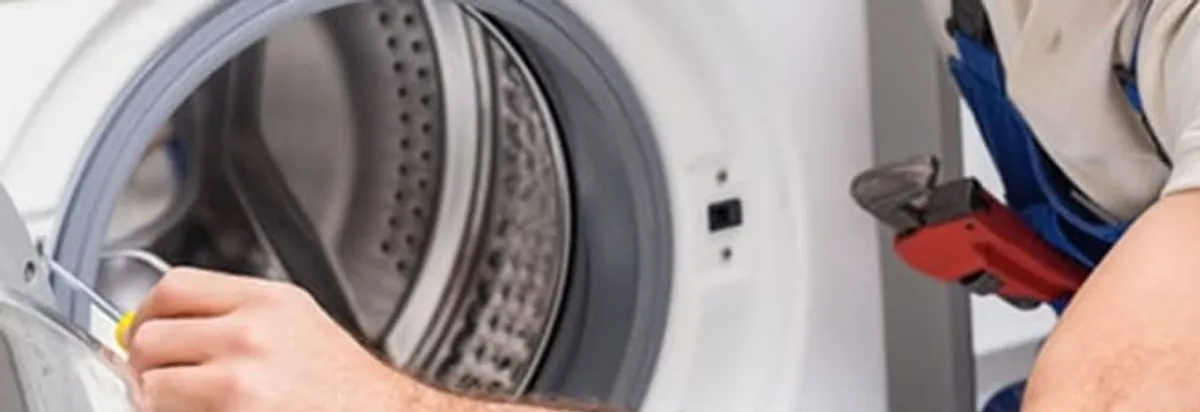 Appliance technician repairing a clothes dryer drum and internal parts in Miami, FL